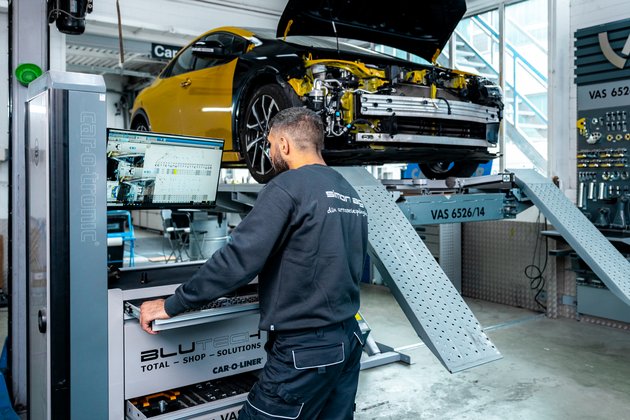 Autoreparatur bei Simon AG: Ein Mitarbeiter steht an einem Computerscreen