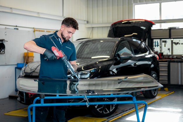 Ein Mitarbeiter von Simon AG wechselt eine Autoscheibe aus